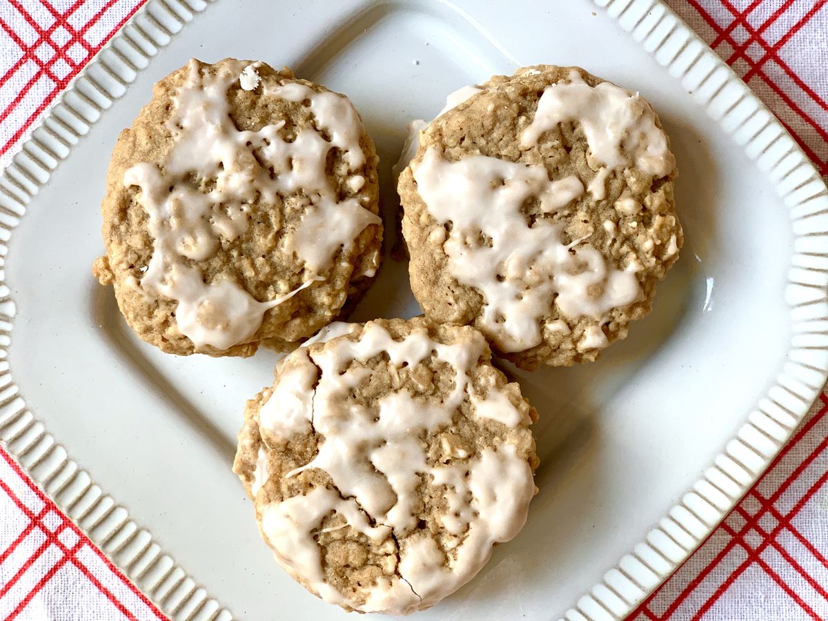 three iced oatmeal cookies on a square plate